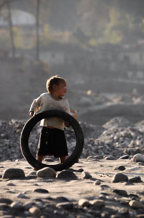 Cute little boy playing with a rubber tyre - I