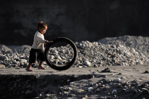 Cute little boy playing with a rubber tyre - II
