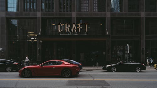 Free Red Sports Car Passing Craft Building Stock Photo