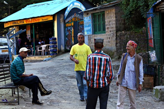 Casual street scene outside a Himalayan tea shop in Dharamkot, India. People gather and converse.