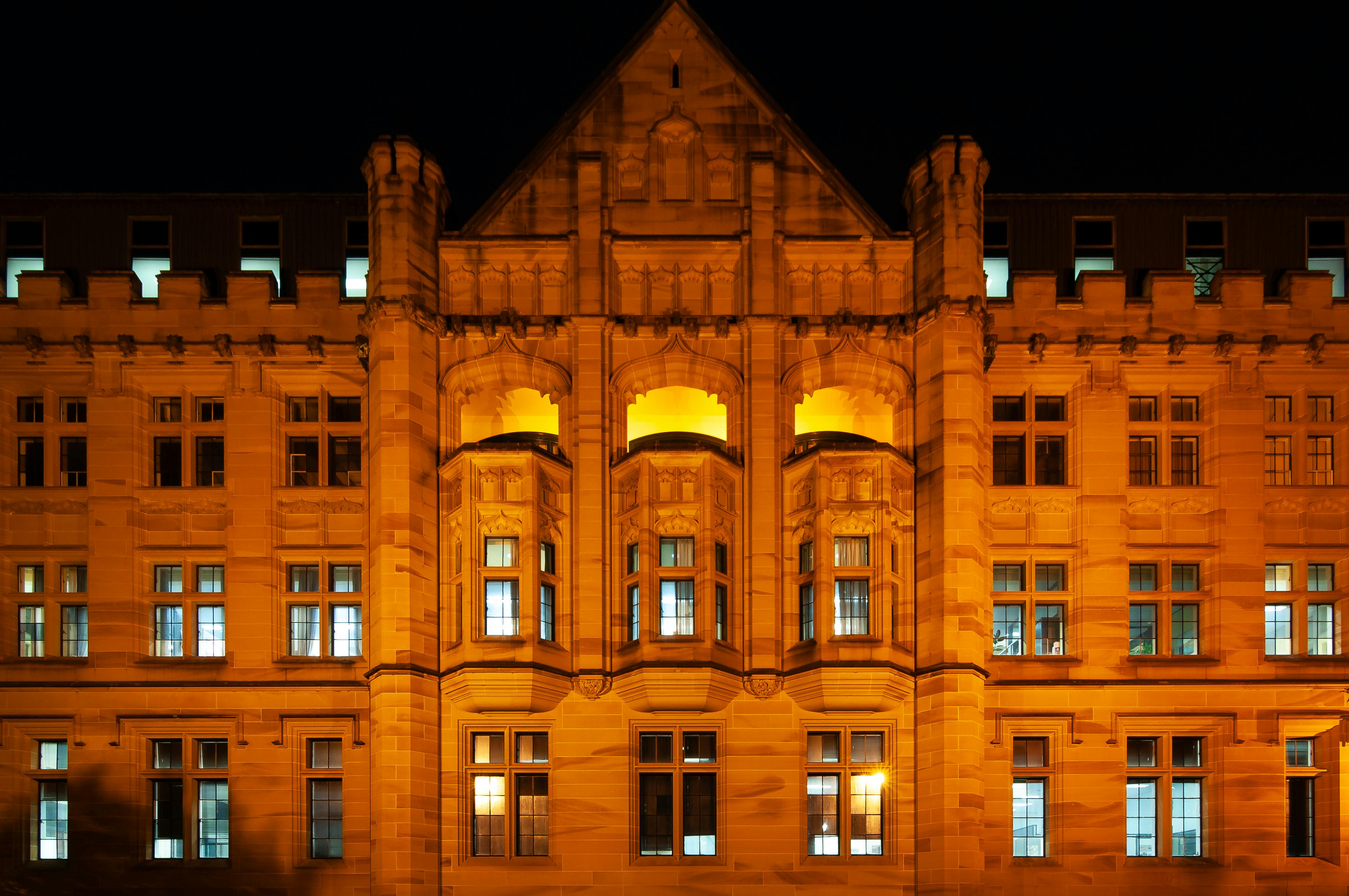 Night view of the illuminated Registrar General's Building, a historical landmark in Sydney.