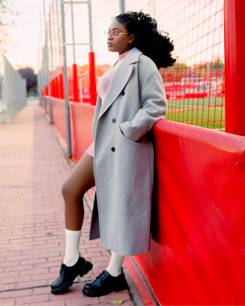 A woman in a coat and white socks posing for a photo