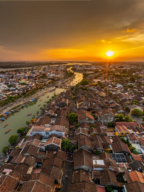 A sunset over a city with houses and a river