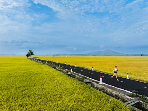 A person running on a road in a field