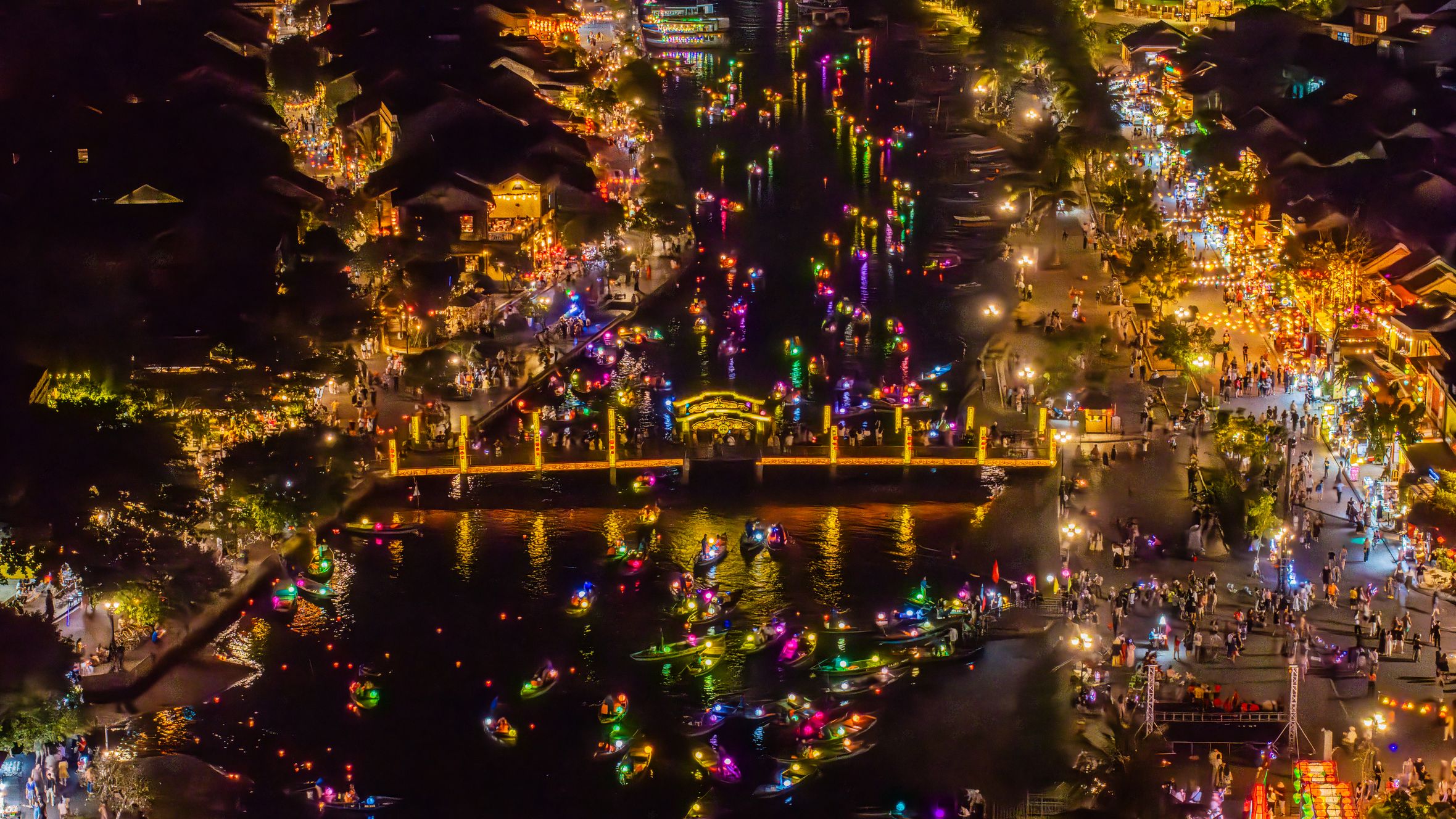 A vibrant aerial shot of Hội An's lantern festival, showcasing colorful lights and bustling waterfront.