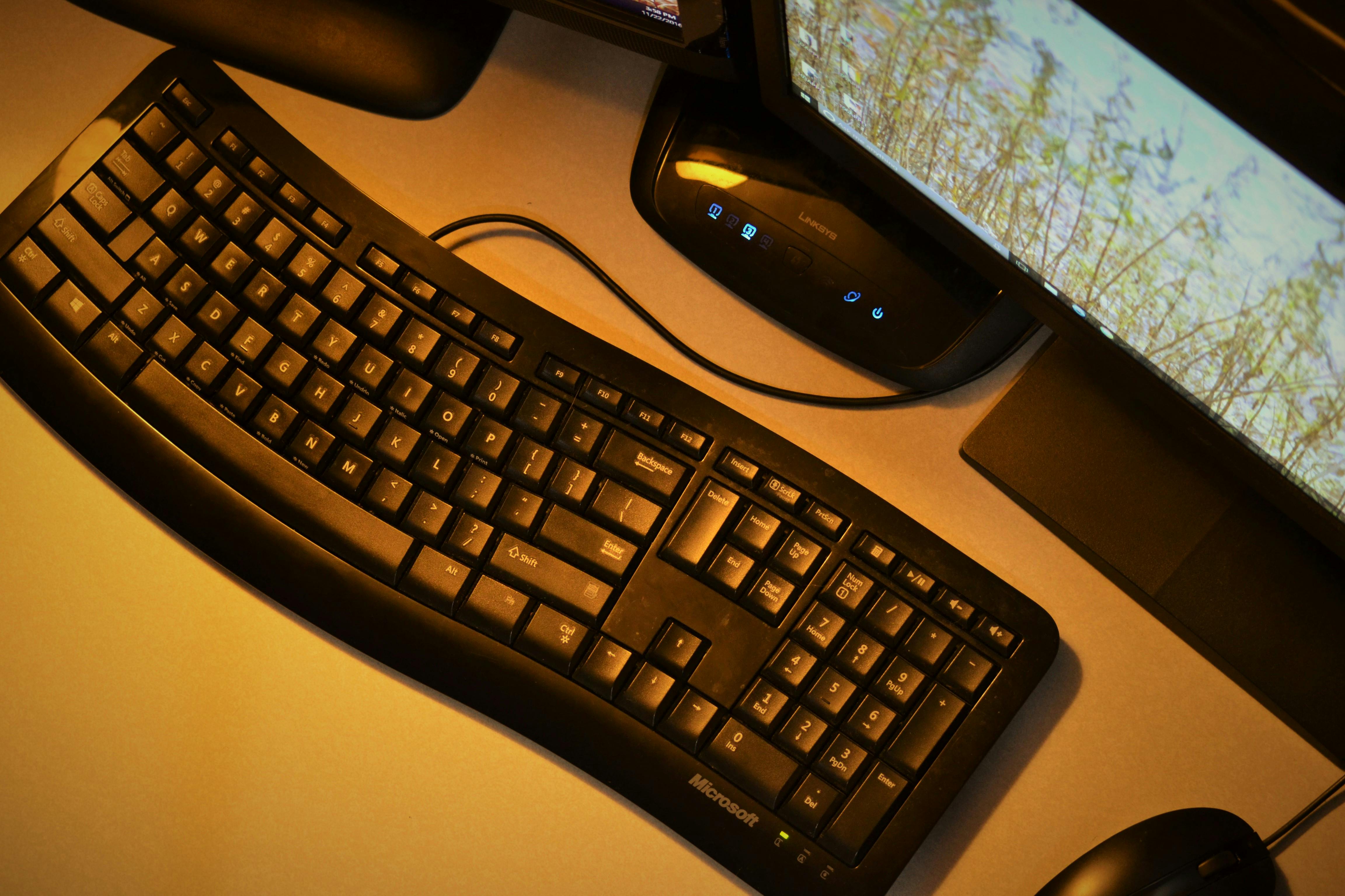 Black Corded Computer Keyboard Near Monitor