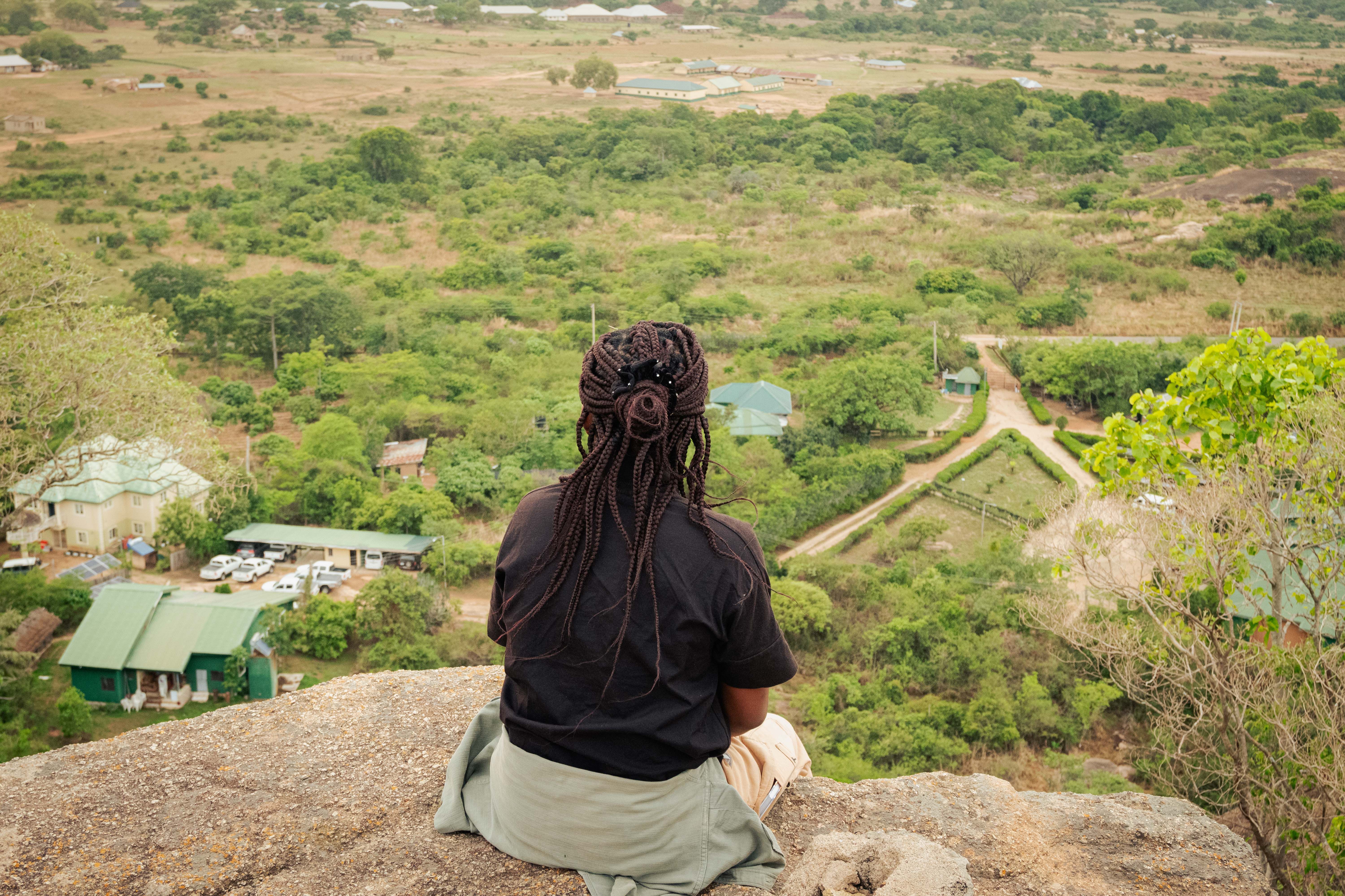 Person sitting on cliff at looking at rural view, Angola