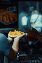 A person holding a plate of fries in front of a person