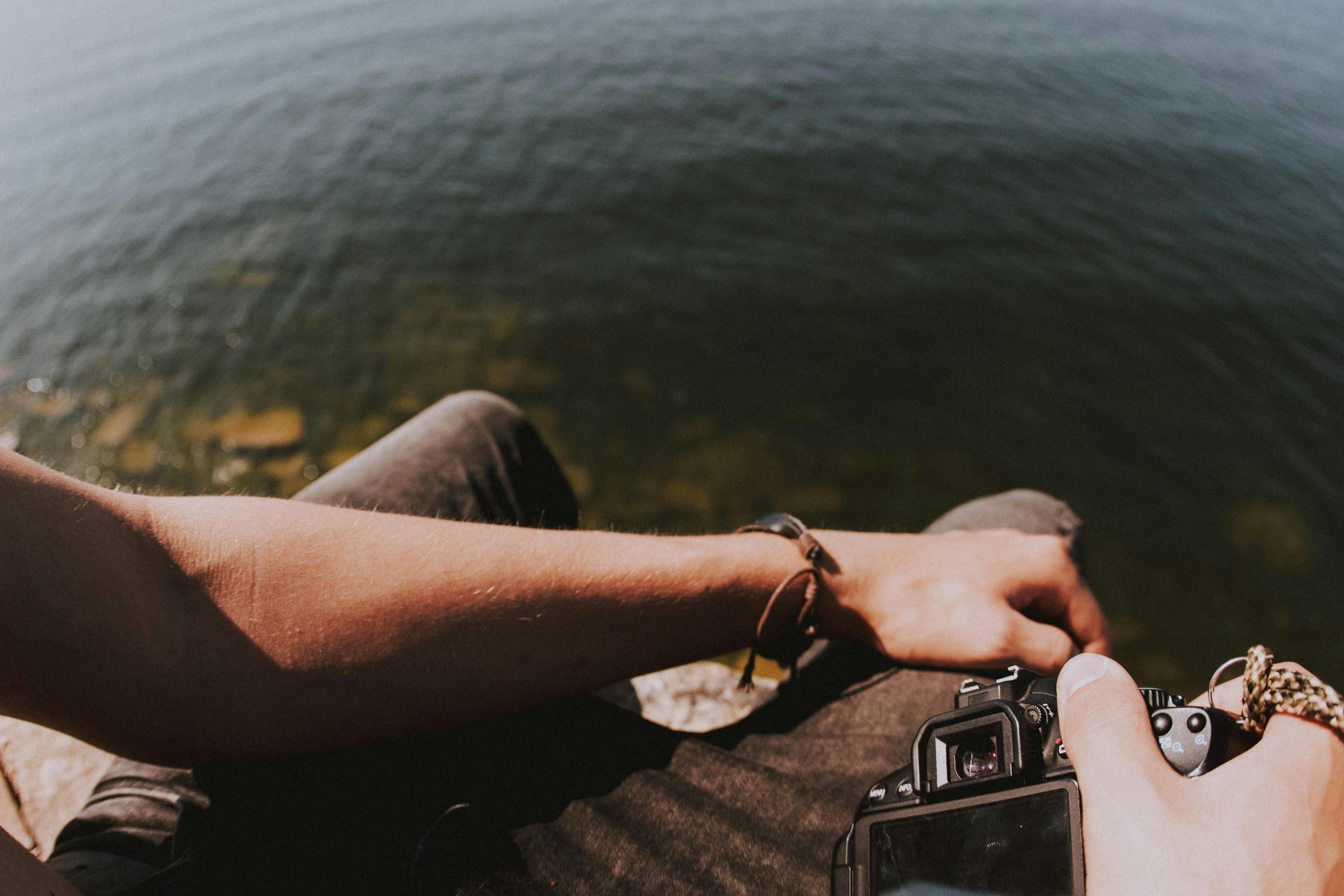 一位摄影师在水头休息，用相机捕捉夏日的宁静时刻