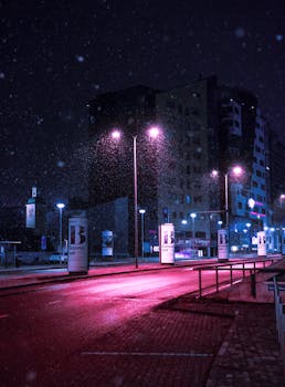 傍晚时分，爱沙尼亚塔林的一条积雪街道上，城市灯光和现代建筑在镜头中展现