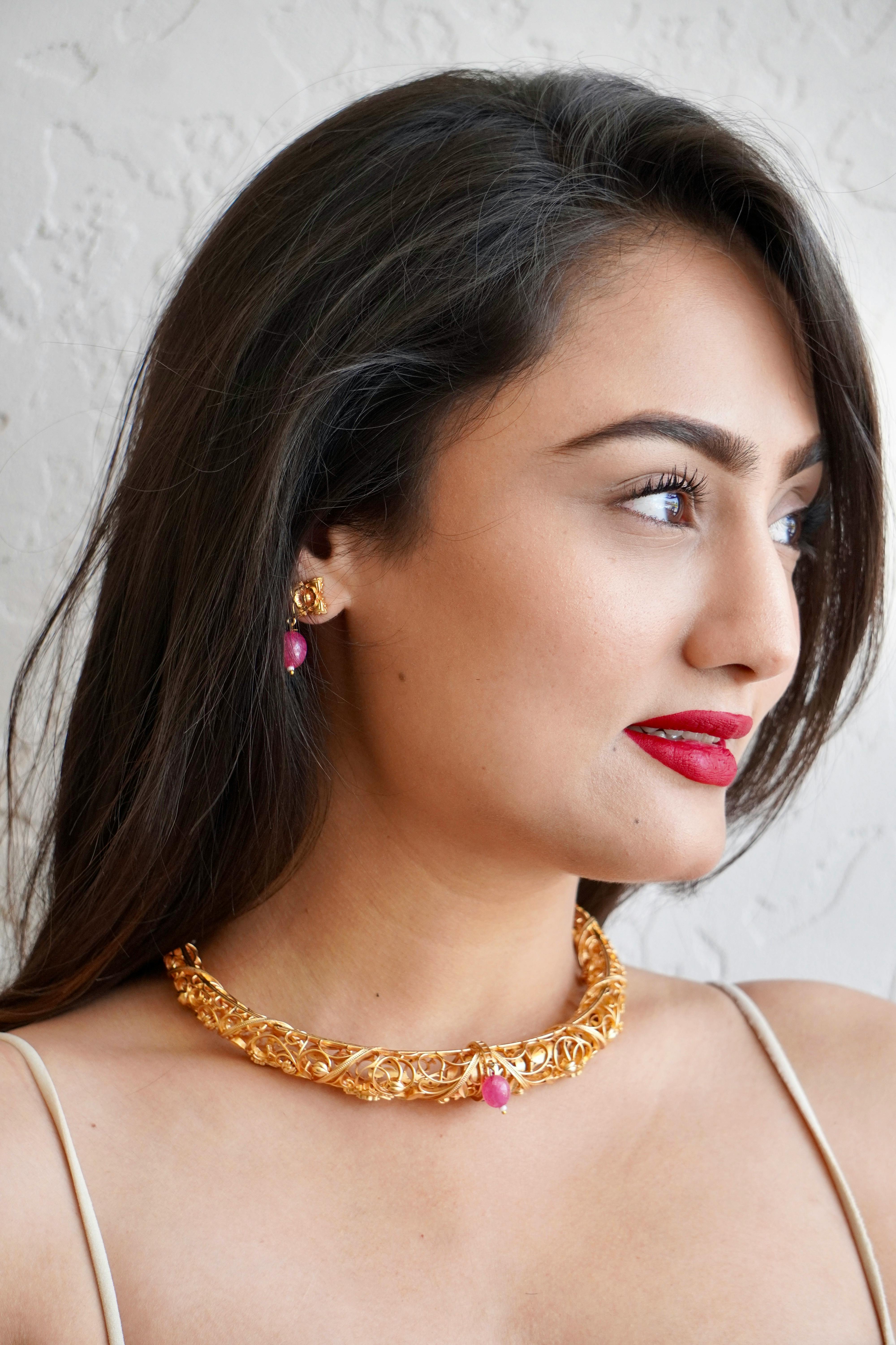 gold jewelry of model wearing necklace and earrings