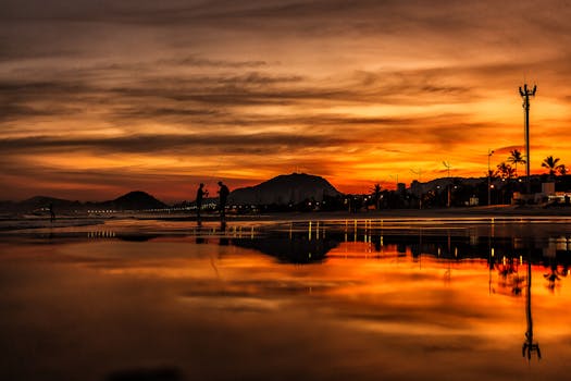 日落时分，渔民剪影倒映在宁静的湖面上，与山脉相映成趣