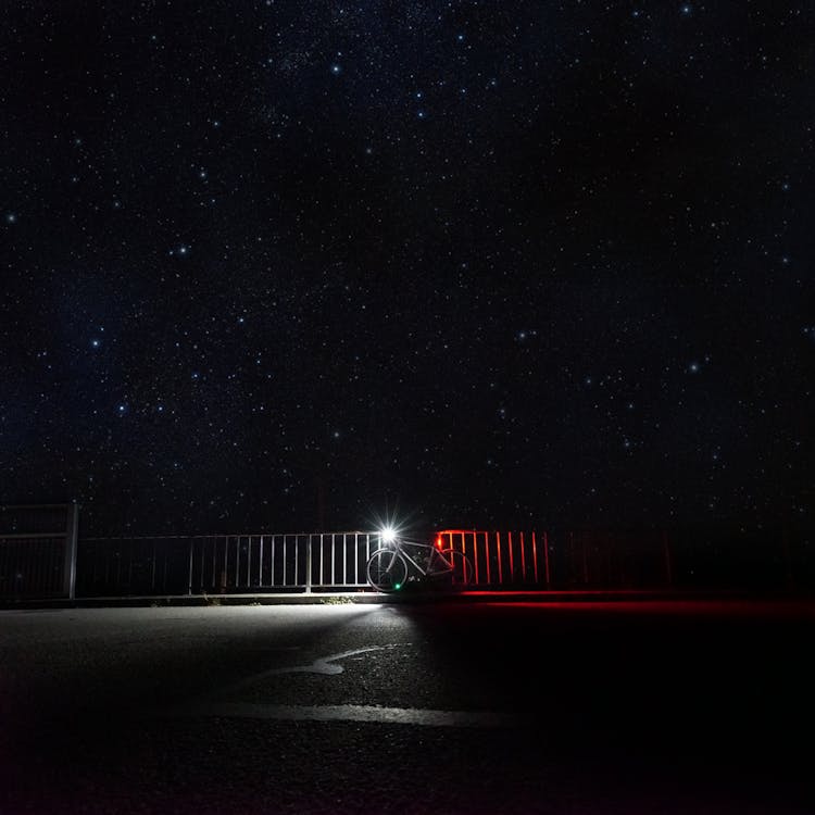 Bicycle With Light Parked Under Starry Sky