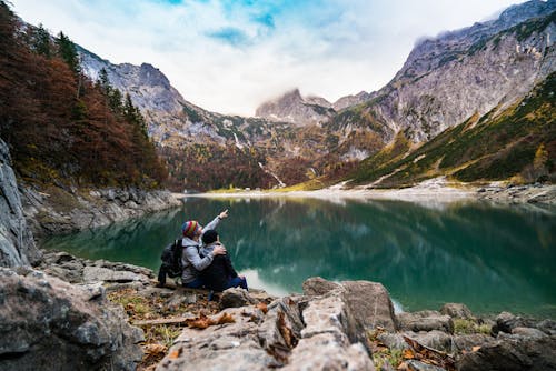 Free Пара, сидящая на скале у озера Stock Photo