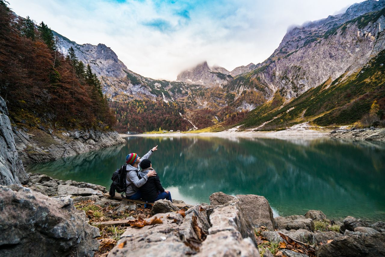 a couple enjoys a scenic view of hallstatt lake surrounded by mountain