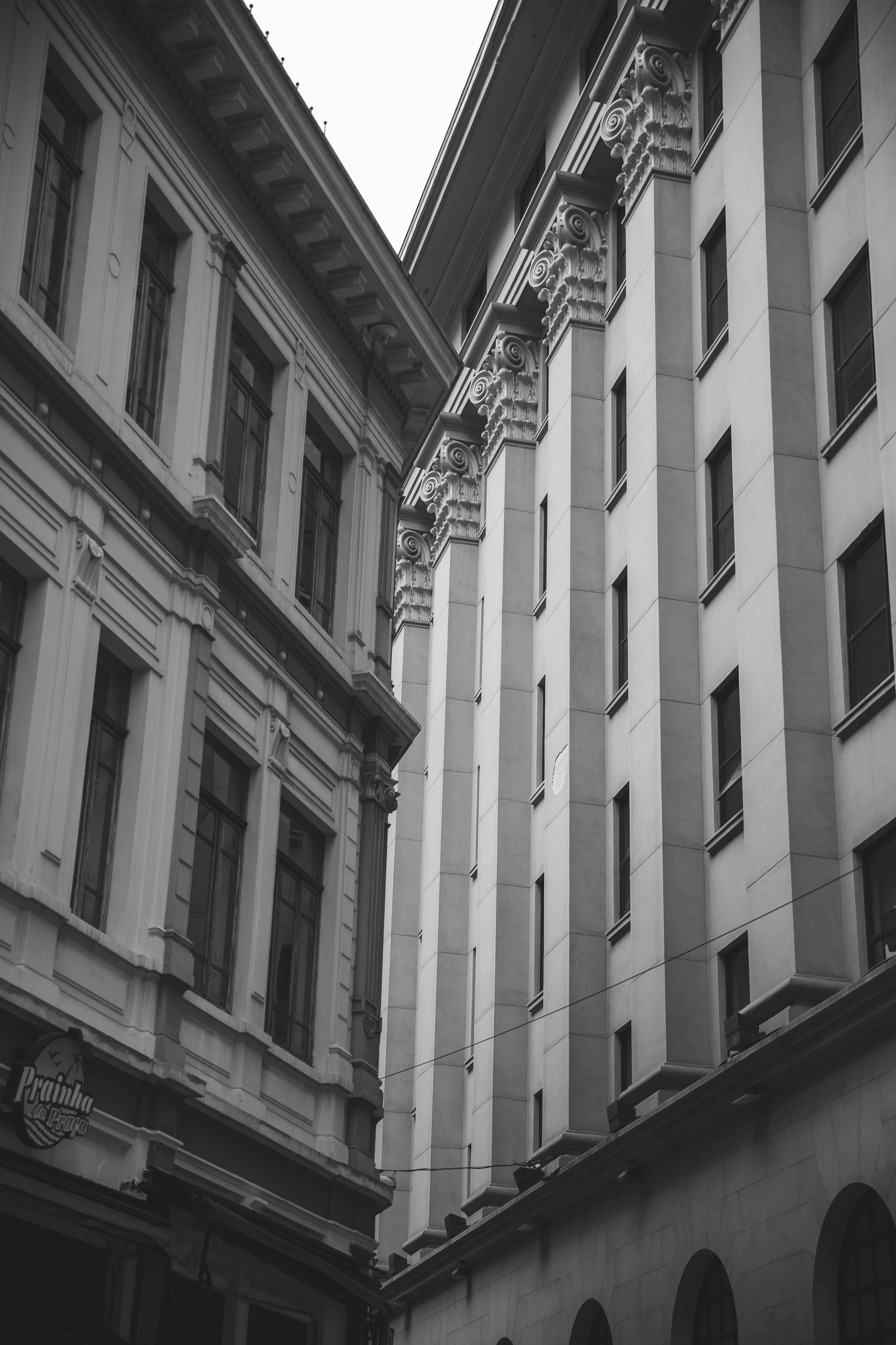从低角度拍摄的黑白照片展示了高耸的古典建筑及其复杂的细节