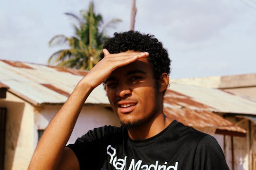 一名非洲男子在质朴的户外环境中，肖像遮挡了阳光