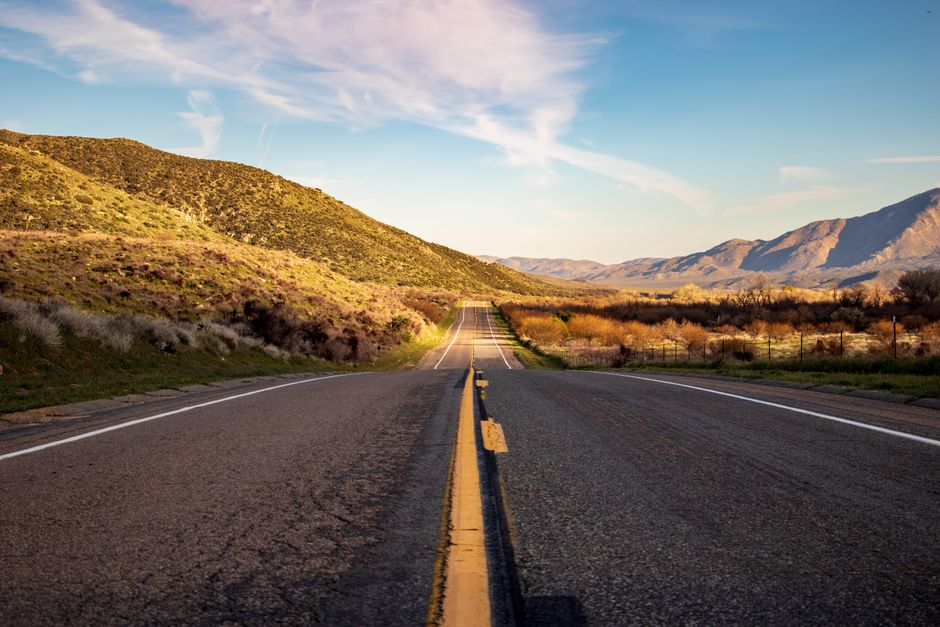 A scenic highway cutting through mountain landscape under a clear sky, perfect for travel and exploration.