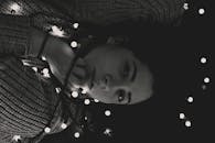 一幅黑白女性艺术肖像被发光的灯串环绕