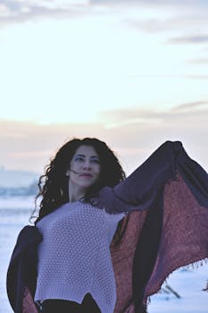 一位穿着舒适毛衣的女人在户外欣赏冬日的日落