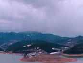 空中拍摄了一幅戏剧性的画面：一个多山岛屿被水和阴云笼罩