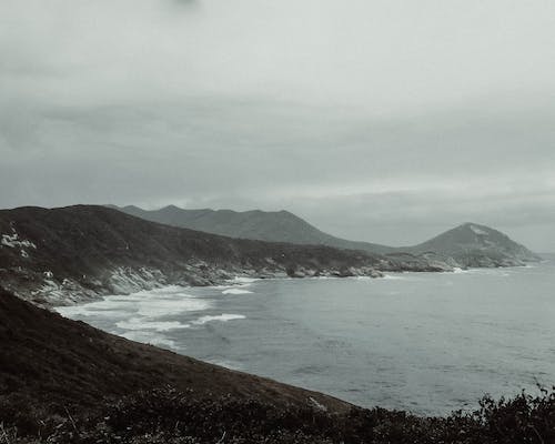 Montagna Che Si Affaccia Sulla Spiaggia Sotto Il Cielo Nuvoloso Grigio