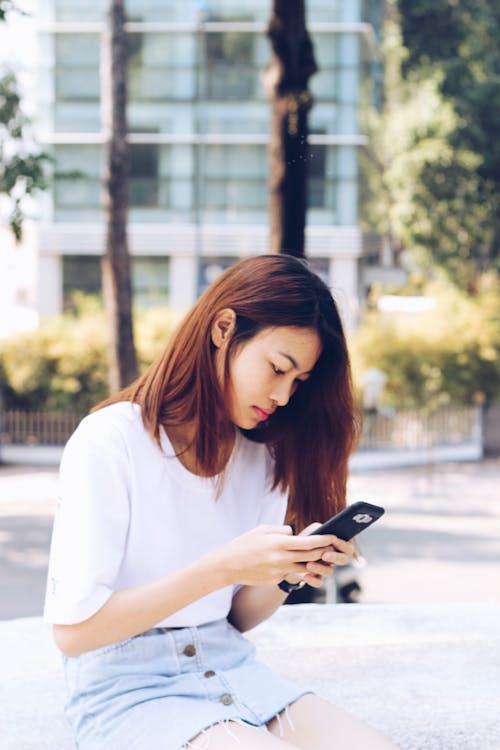Woman Sitting Holding Phone on Focus Photography