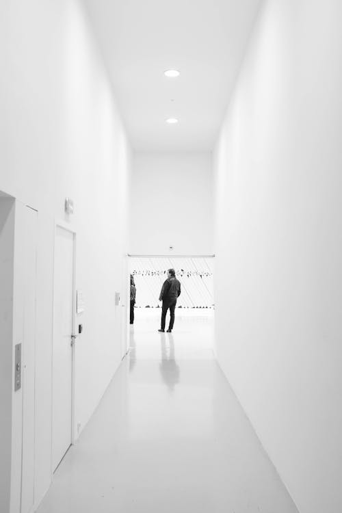 Man Standing Near White Wall
