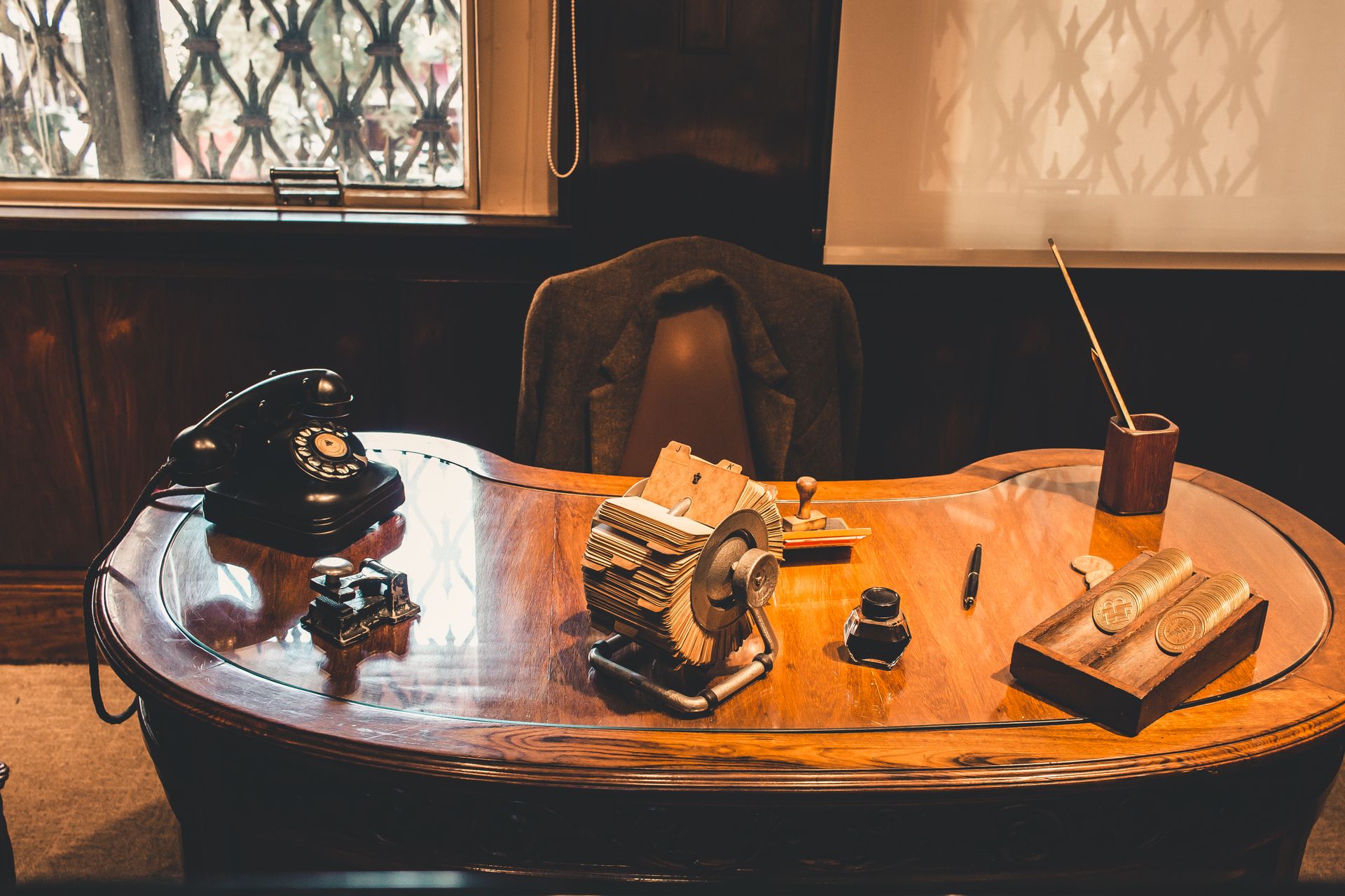 Classic office desk setup with rotary phone, files, and wood design, capturing a vintage vibe.