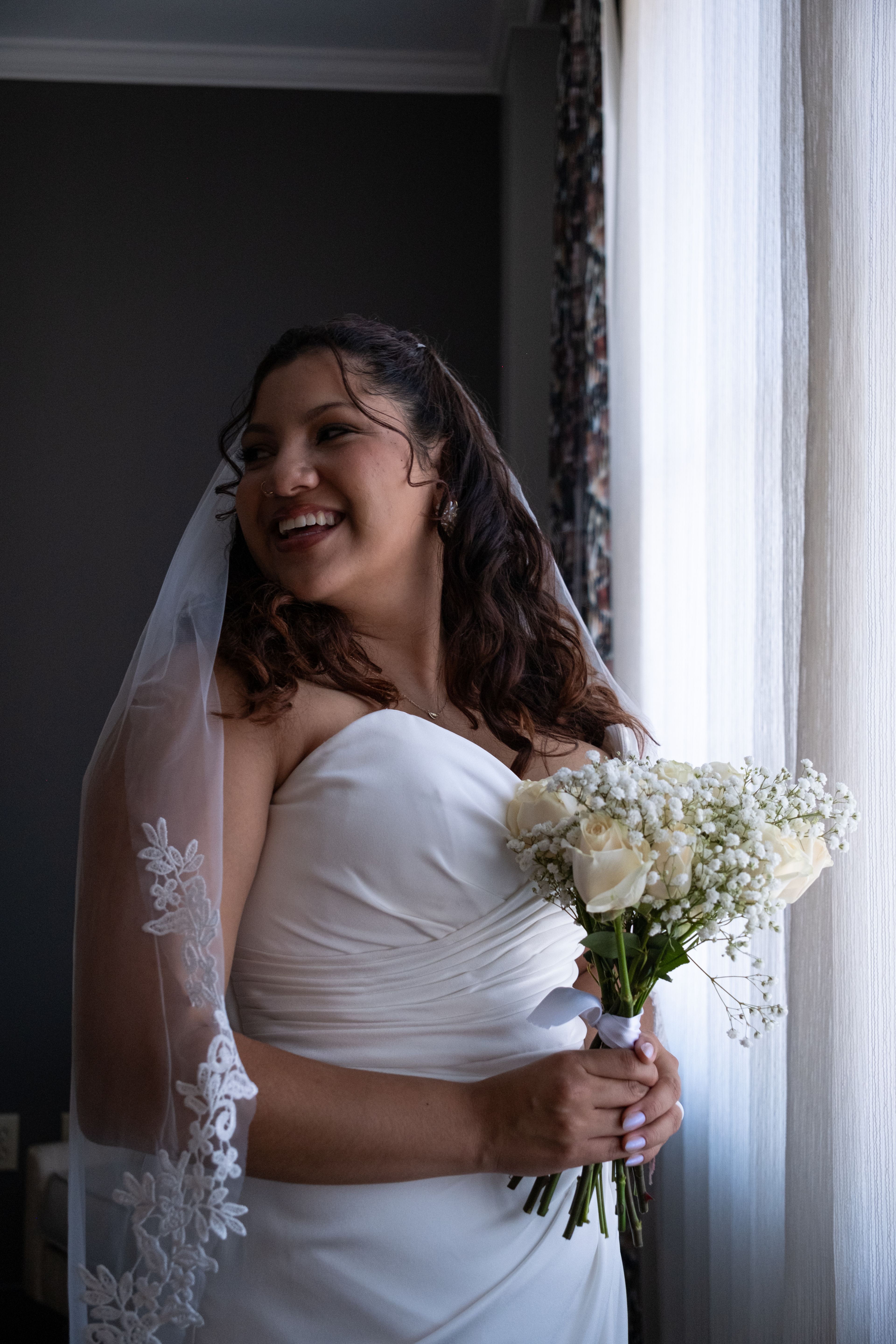 A bride with her bouquet by the window light