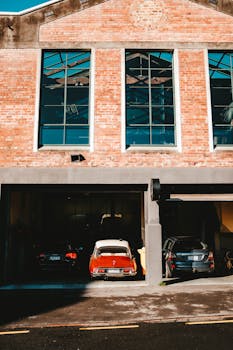 A modern brick building exterior with cars parked in the garage, showcasing urban architectural design.