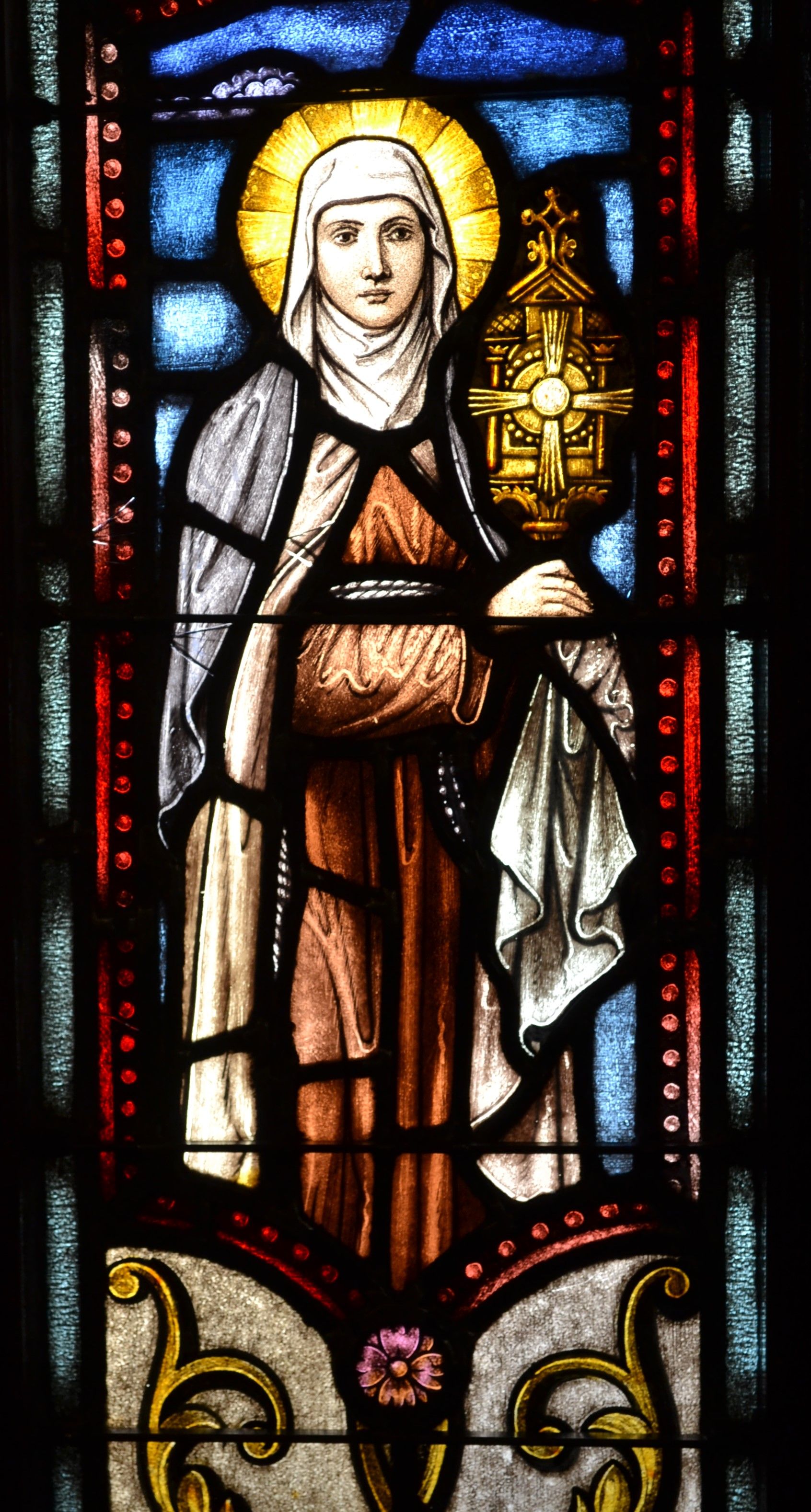 Elegant stained glass depicting a sacred Christian figure in vibrant colors.