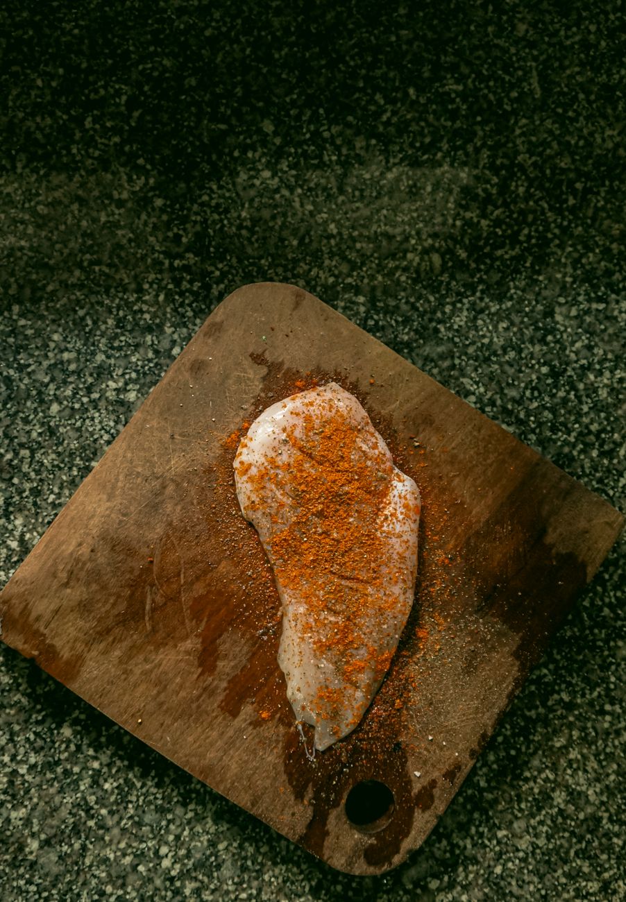 Jamaican jerk chicken with scotch bonnet peppers and traditional spices arranged on a wooden cutting board