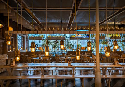 Warm, cozy indoor restaurant setting with hanging Edison bulbs in Bengaluru, India.