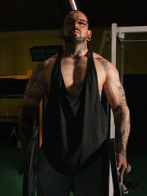 A man with tattoos standing in a gym