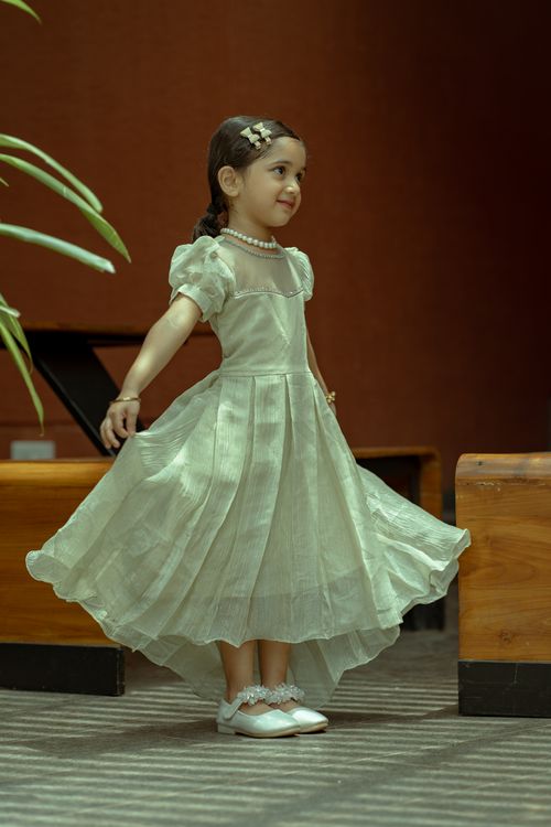 Free Charming young girl in a flowing white dress gracefully spinning indoors. Stock Photo