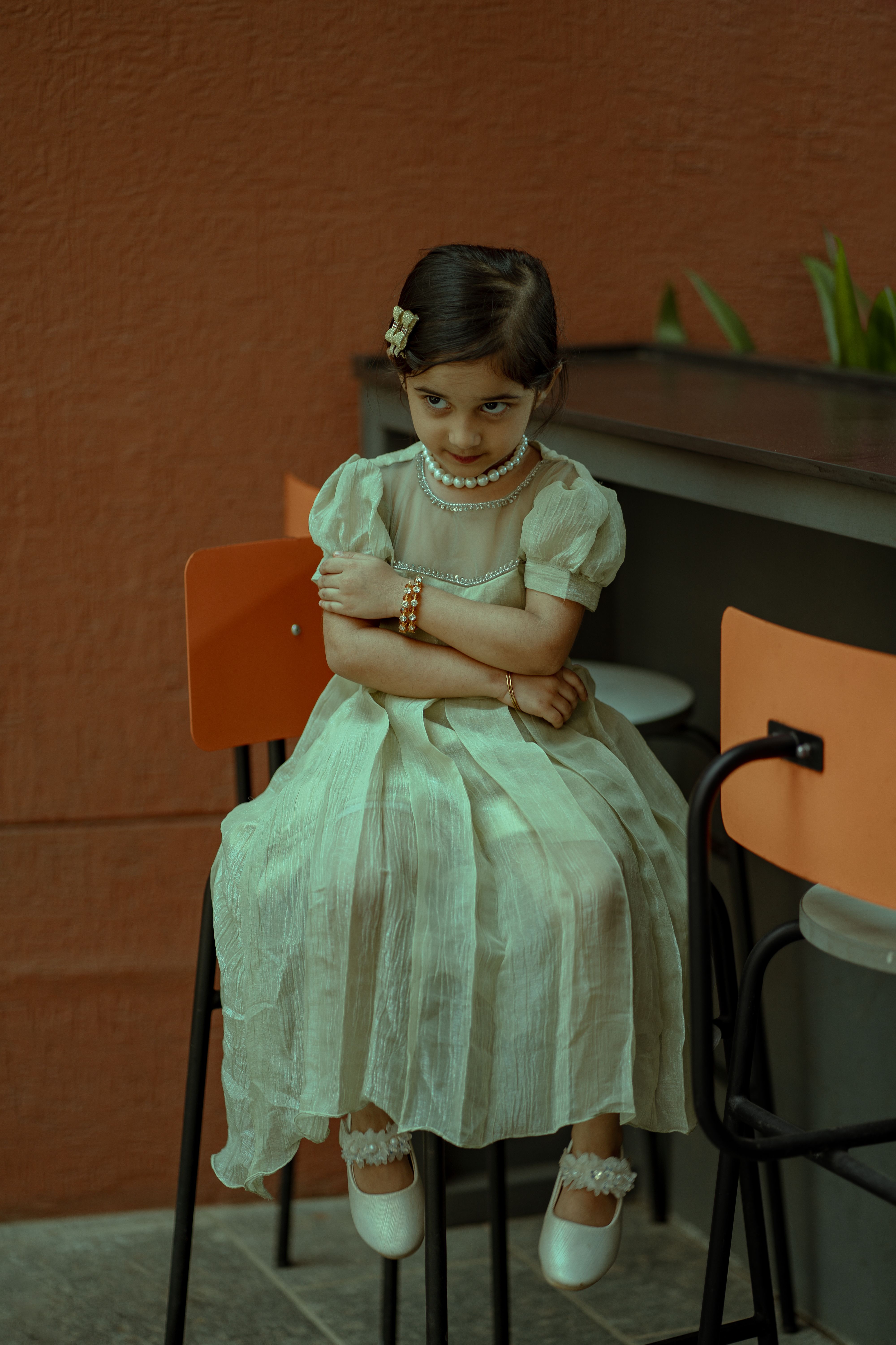 Portrait of a cute girl sitting on a chair · Free Stock Photo