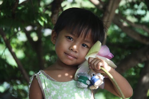 Girl Holding Keychains Et Une Fleur