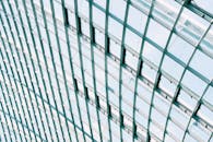 从这个角度拍摄的玻璃和钢结构，探索现代建筑的优雅