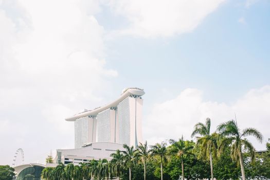 在晴朗的天空下，滨海湾金沙被热带树木环绕