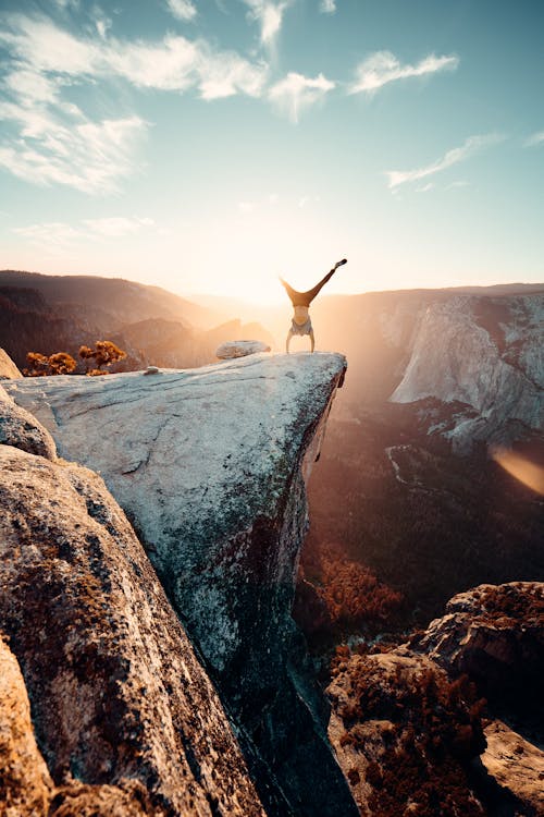 Free Man Doing Hand Stand on Mountain Stock Photo