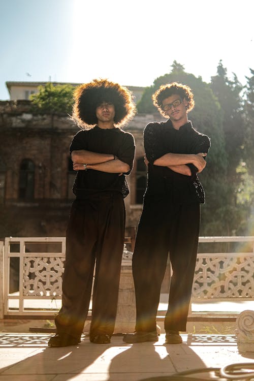 Two men with afro hair standing in front of a building