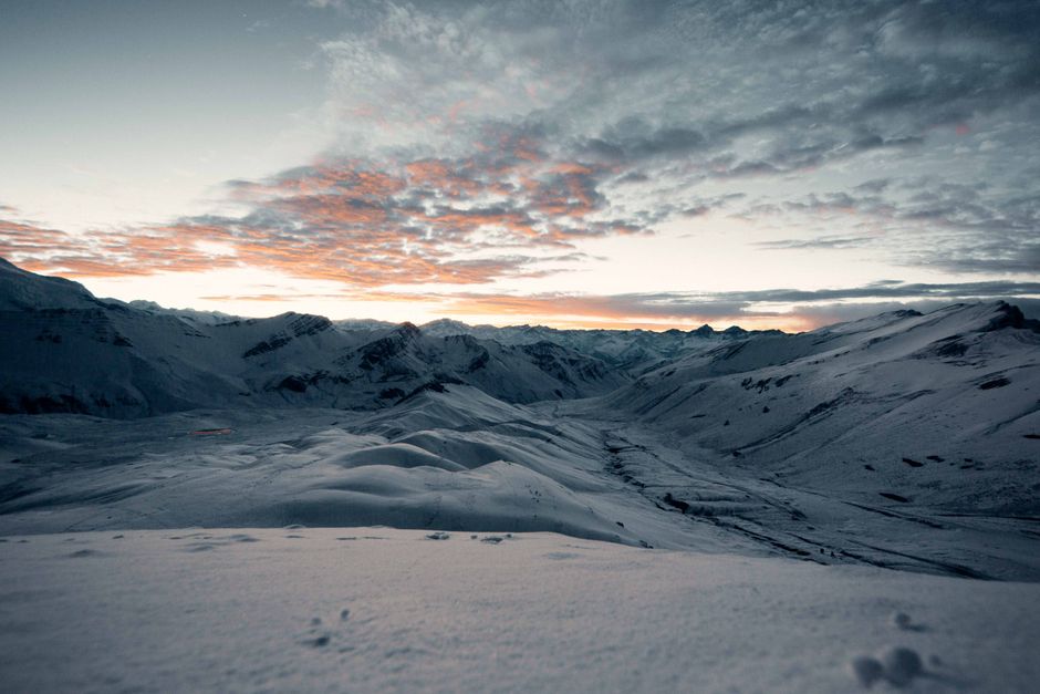 Stunning dawn view of snow-covered mountains, capturing the winter sky's vibrant hues.
