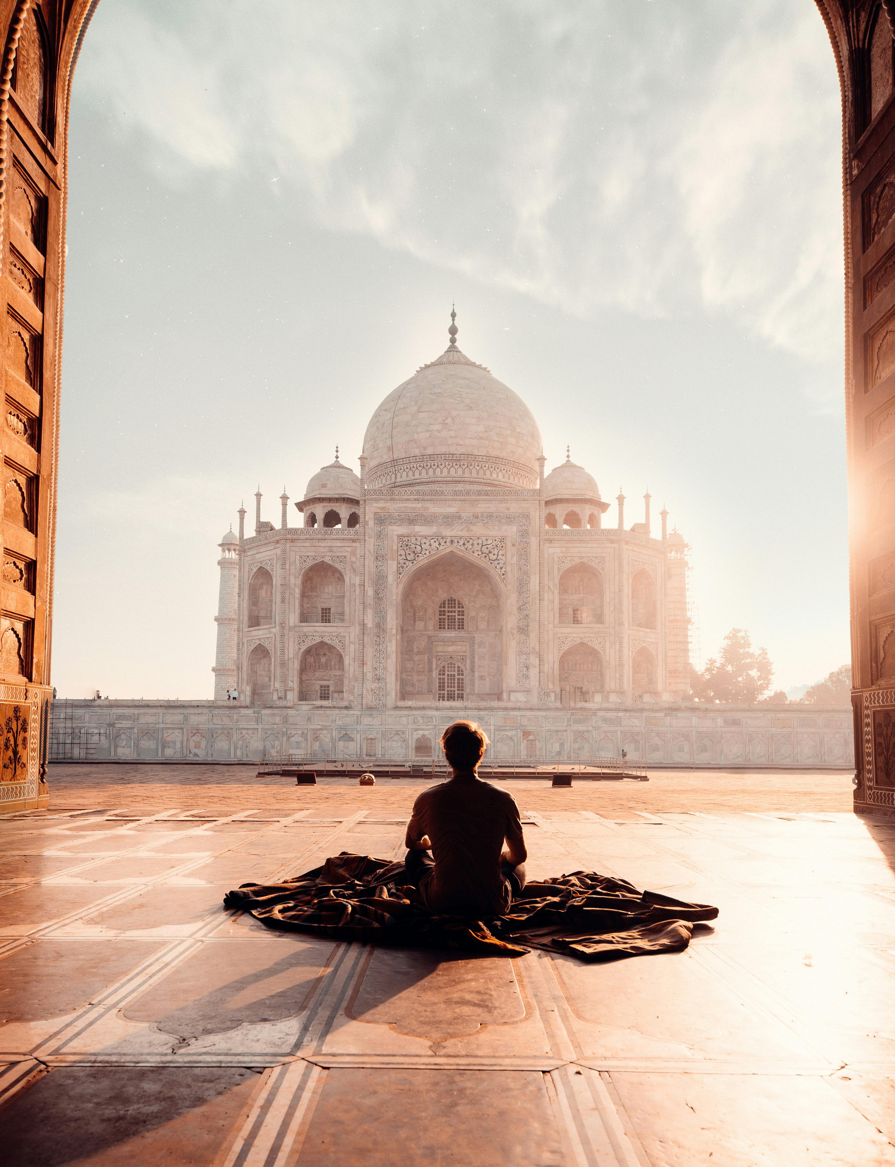 person sitting in front of the taj mahal