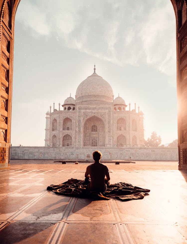 Person Sitting In Front Of The Taj Mahal