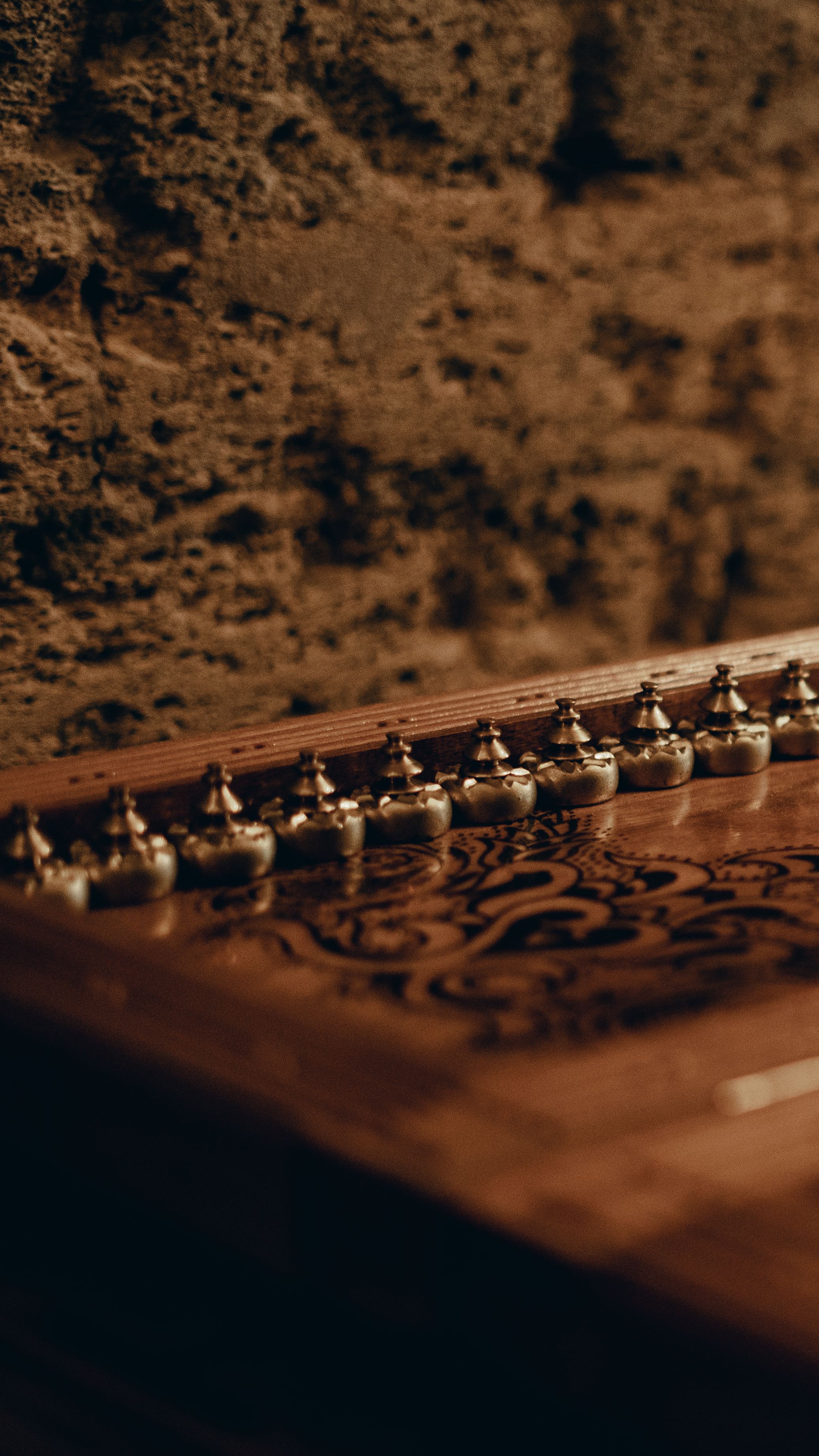 Close-up of a vintage board game with ornate design against a rustic wall.