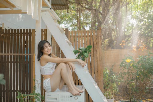 A woman in white underwear sitting on a ladder