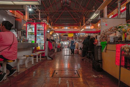 Free Indoor market scene bustling with food stalls and shoppers in a lively atmosphere. Stock Photo