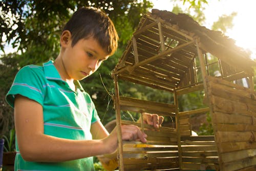 木造住宅ミニチュアを作る少年
