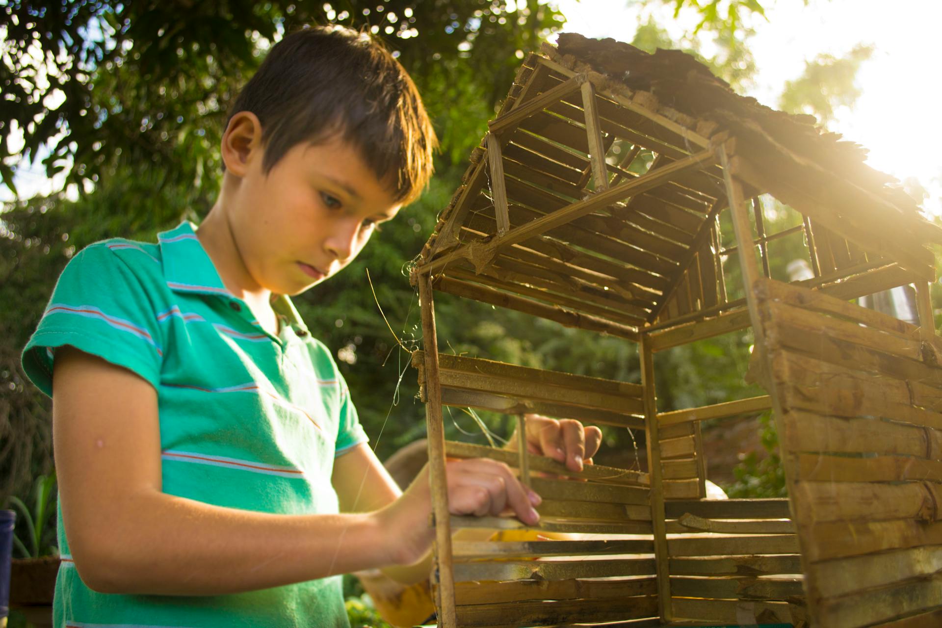 Jongen maakt houten huisjes in miniatuur